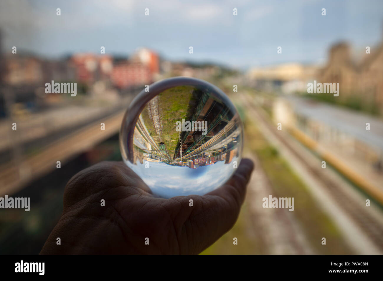 I binari della ferrovia si riflettono su una sfera di vetro Foto Stock