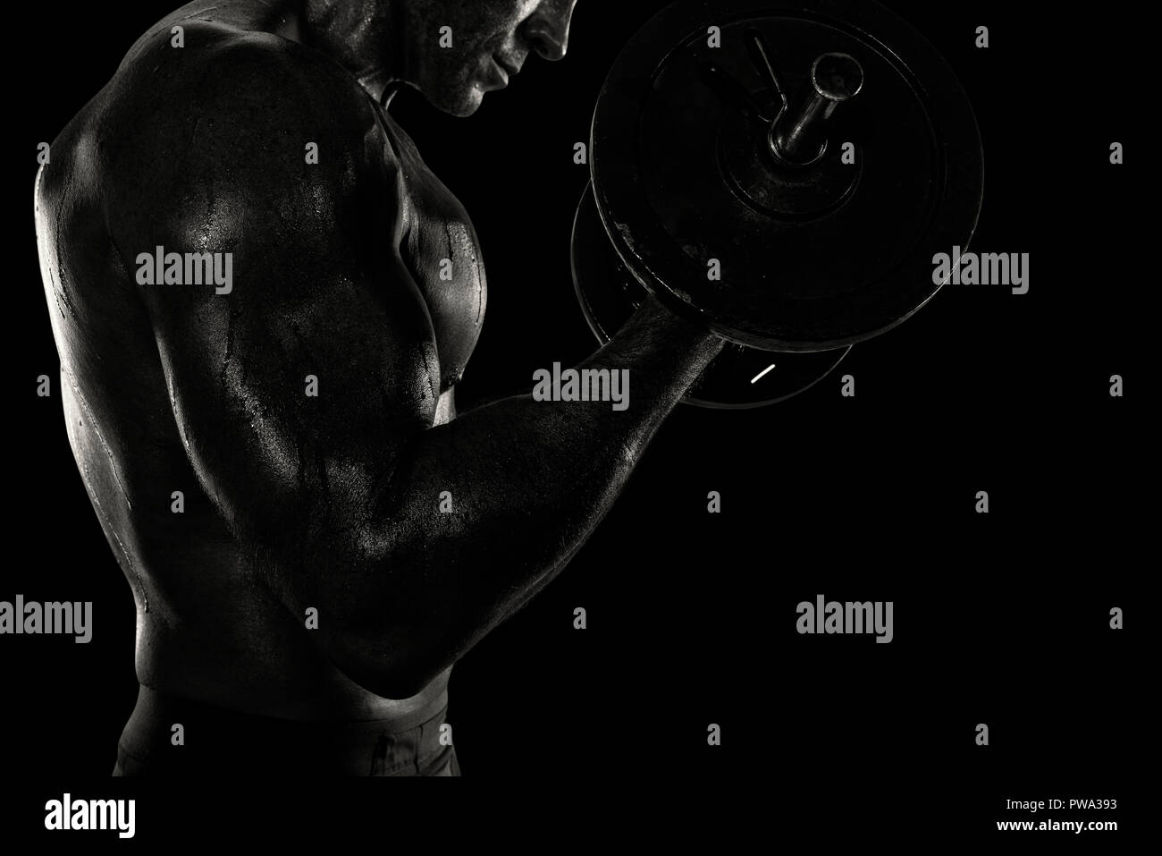Athletic uomo lacerti di allenamento in palestra. effetto bianco e nero Foto Stock