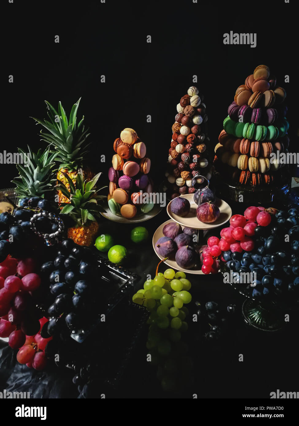 Amaretti colorati,cioccolato artigianale di caramelle,l'ananas, fichi, uva da tavola da dessert Foto Stock