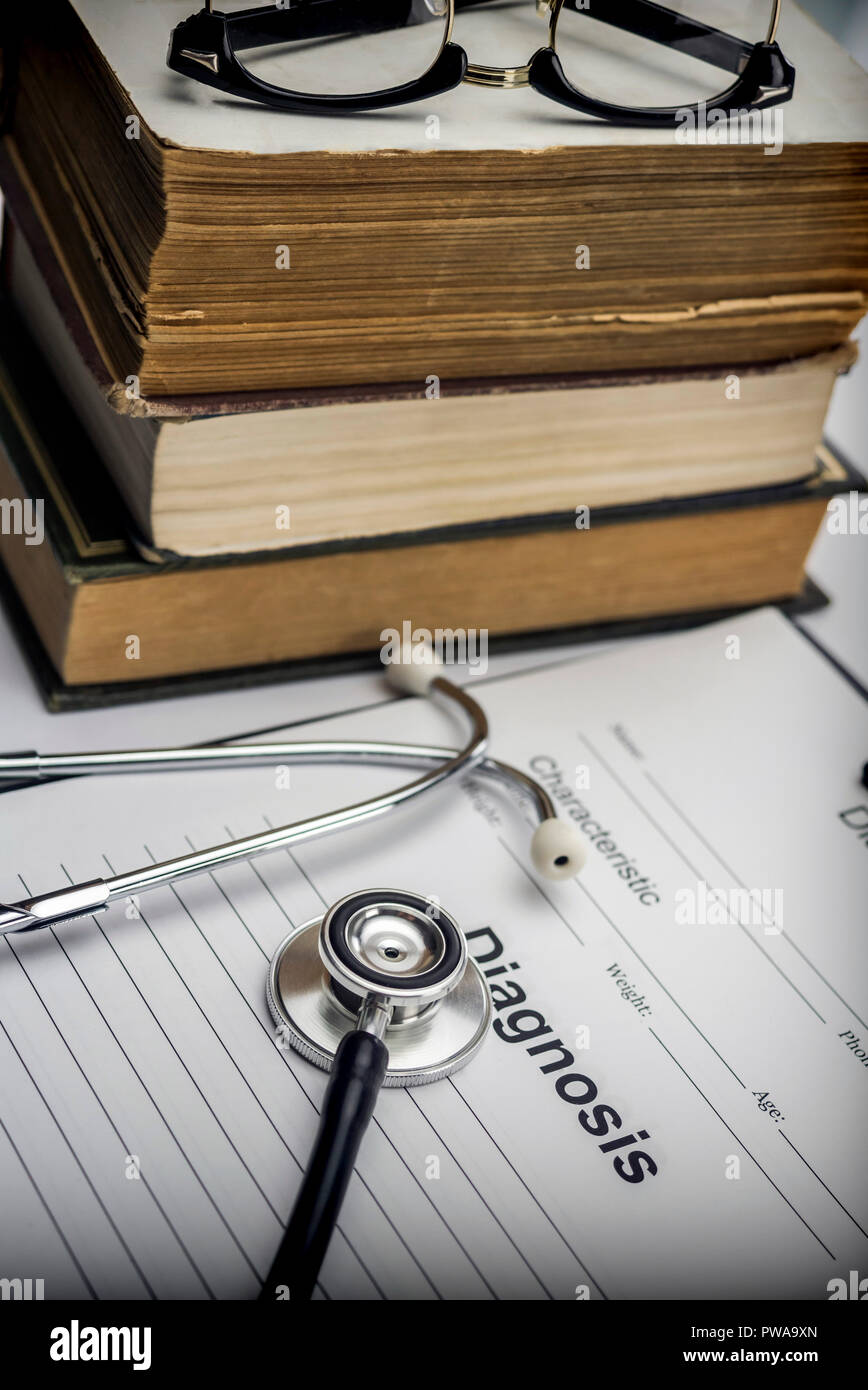 Molti libri di medicina con uno stetoscopio e un modulo di diagnostica, immagine concettuale Foto Stock