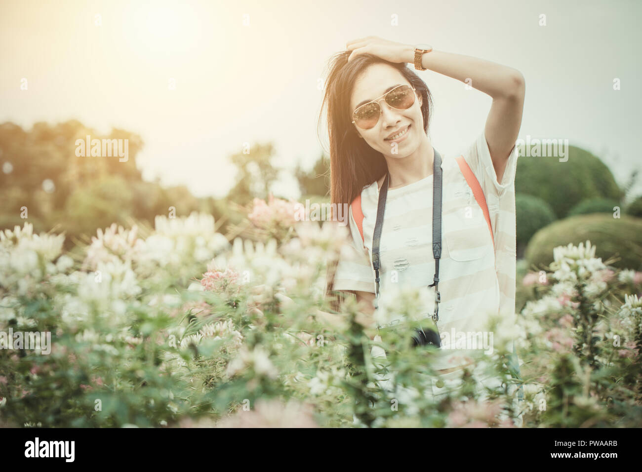 Ragazza asiatica rilassarsi godersi la vacanza con la fotografia fiore hobby nel parco vintage tono colore Foto Stock