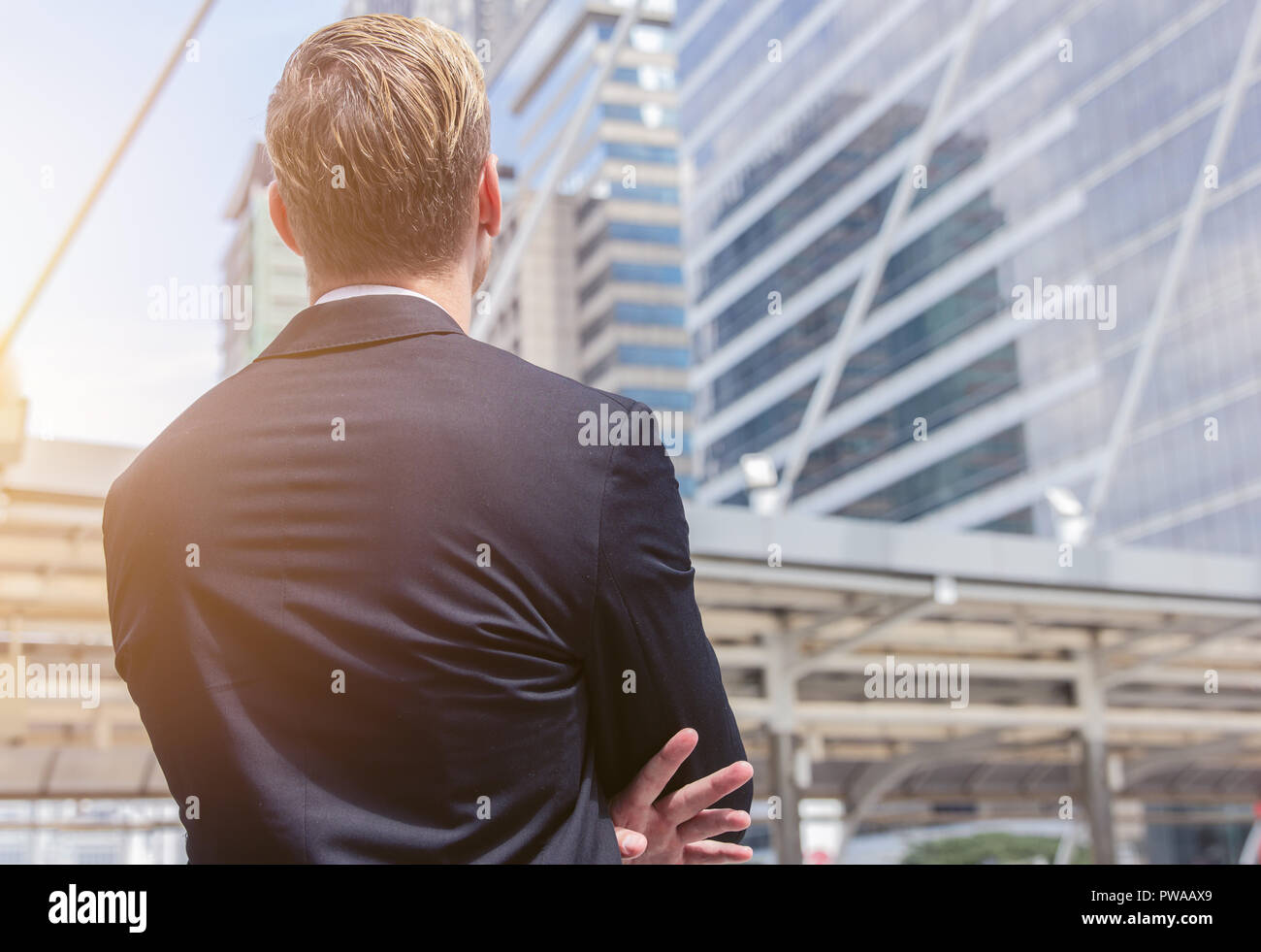 Vista posteriore di imprenditore caucasico guardando ufficio edificio sfondo per business vision concept Foto Stock
