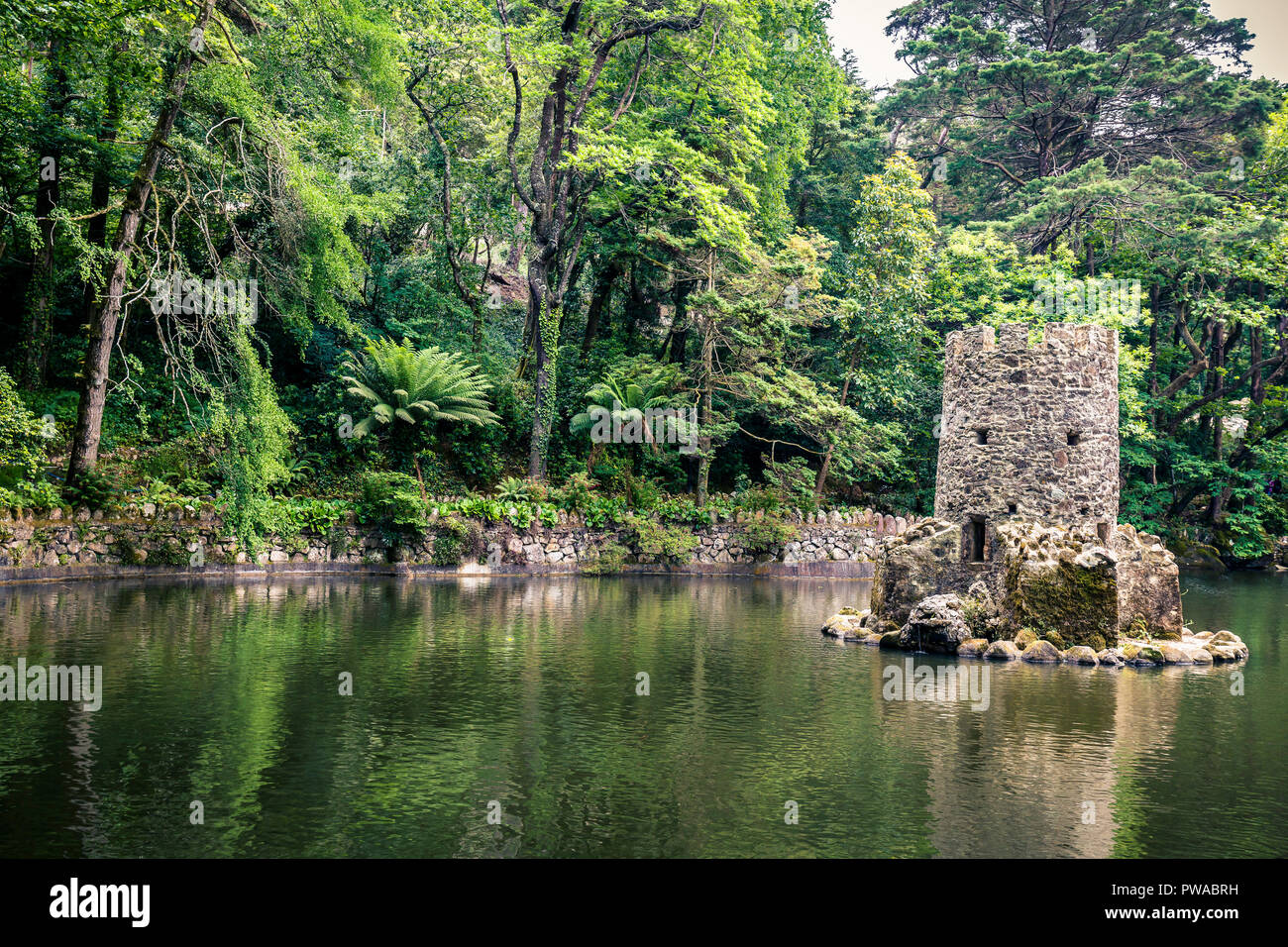 Tower piccolo resti in un laghetto nei giardini della pena il Palazzo Nazionale, Sintra, Portogallo Foto Stock