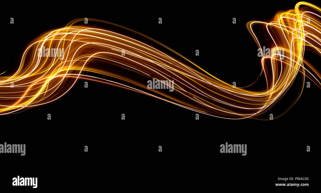 Una lunga esposizione di luce fotografia pittura, curva di Linee di neon vibranti metallizzato oro giallo su sfondo nero Foto Stock