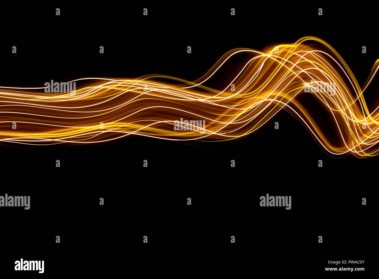 Una lunga esposizione di luce fotografia pittura, curva di Linee di neon vibranti metallizzato oro giallo su sfondo nero Foto Stock