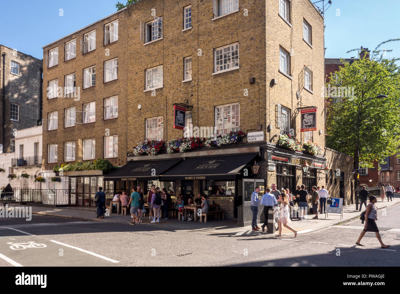 Persone sedevano fuori Mabel's Tavern, Mabledon Place, Bloomsbury, nr King's Cross, London, Regno Unito Foto Stock