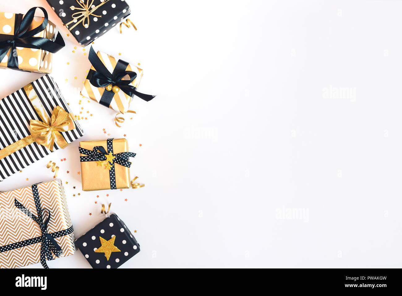 Vista superiore delle confezioni regalo in vari nero, bianco e disegni dorati. Laici piana, copia dello spazio. Un concetto di Natale, Capodanno, Festa di compleanno evento. Foto Stock