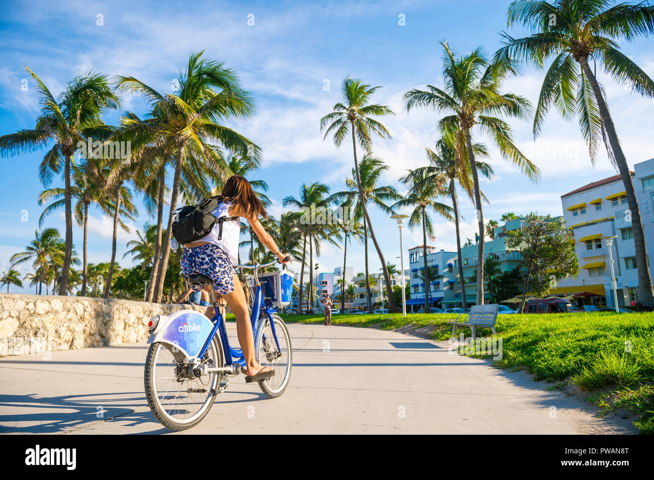 MIAMI - circa settembre, 2018: una giovane donna passa su un Citibike, un marchio che ha goduto di un esclusivo di bike-sharing agreement con Miami Beach. Foto Stock