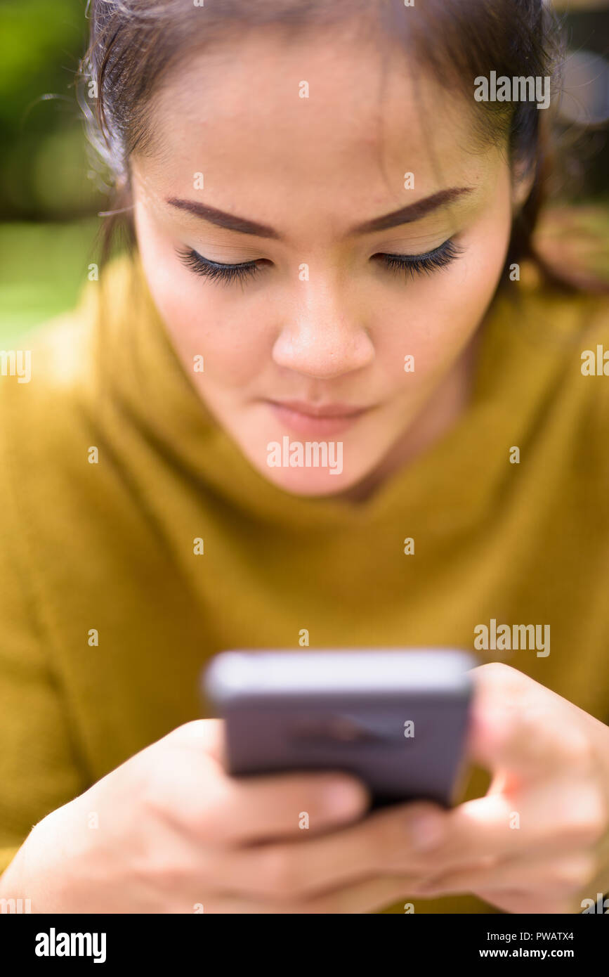 Close-up di donna asiatica utilizzando il telefono cellulare Foto Stock