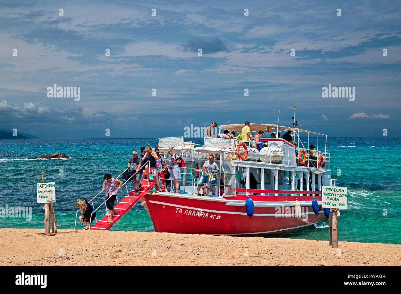 Imbarcazione turistica che arrivano a Megalos Aselinos beach, presso la costa nord dell' isola di Skiathos, Sporadi settentrionali, Magnessia, Tessaglia, Grecia. Foto Stock