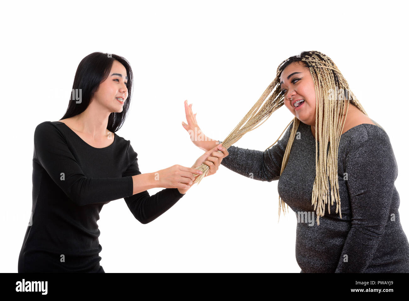 Giovani felici Asian transgender donna sorridente mentre si tira i capelli o Foto Stock