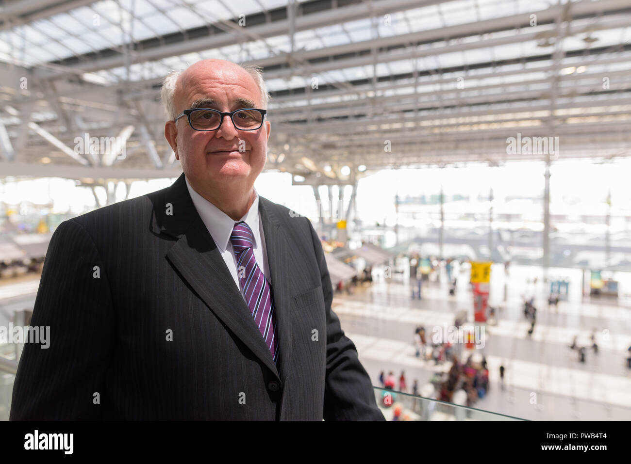 In sovrappeso imprenditore senior lounging intorno all'aeroporto di divieto Foto Stock