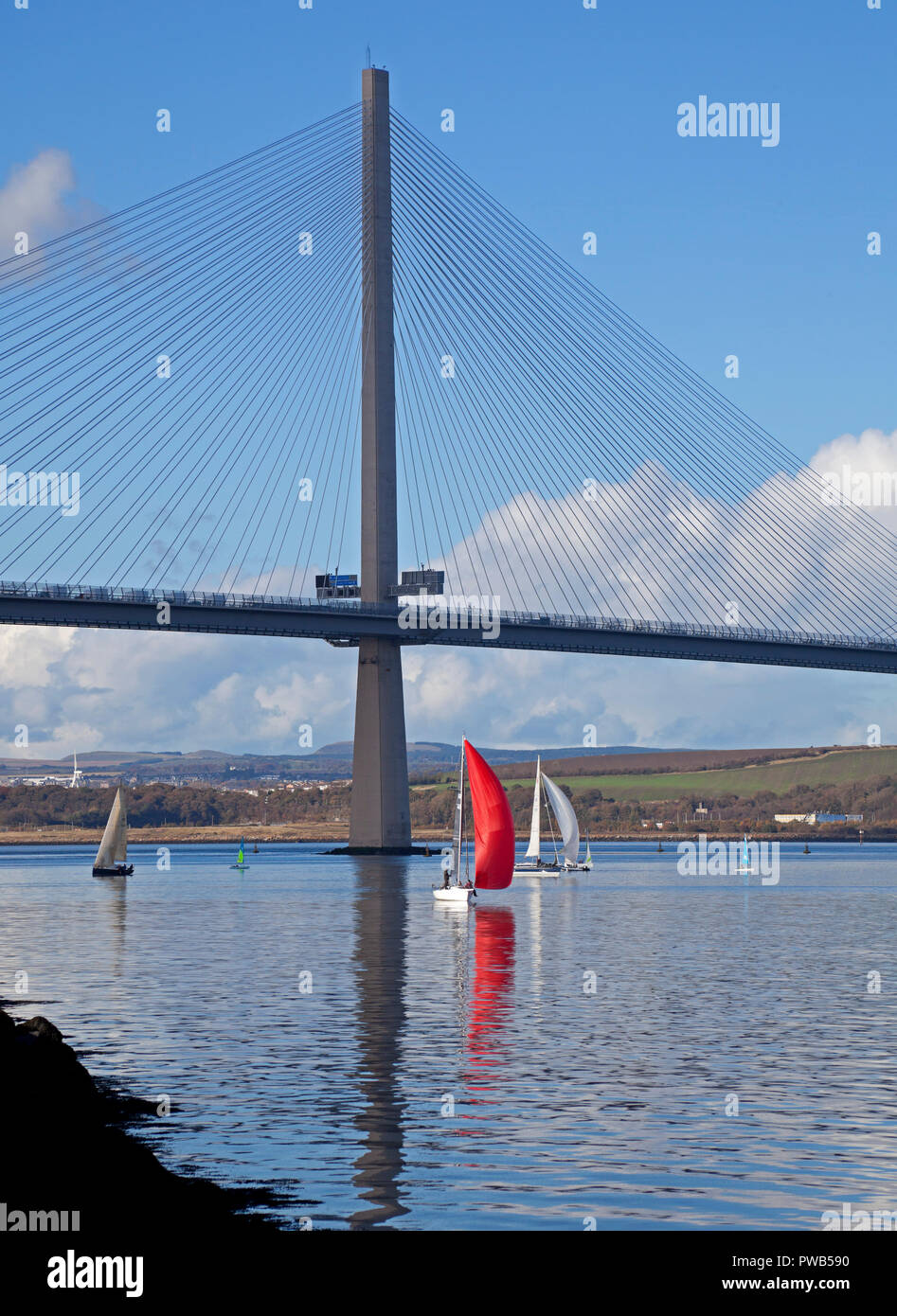 Edimburgo, Scozia, Regno Unito. Il 14 ottobre 2018. Regno Unito meteo, dopo una molto nuvoloso fredda mattina il sole è apparso nel primo pomeriggio e a 13 gradi si sentiva caldo sotto il sole, non molto vento per assistere gli equipaggi delle piccole imbarcazioni a vela in Forth Estuary sotto la Queensferry attraversando ponte su un bellissimo pomeriggio per la navigazione a vela. Foto Stock