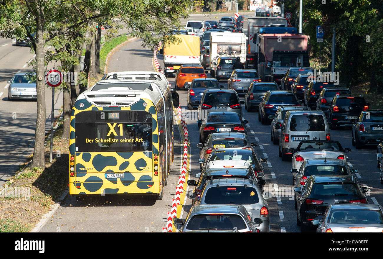 12 ottobre 2018, Baden-Wuerttemberg, Stoccarda: 12 ottobre 2018, Germania Stoccarda: durante un test drive, un autobus di linea X1 passa automobili ferme. Dal 15 ottobre, il bus di linea verrà eseguito ogni 5 minuti su un Stuttgart percorso principale da Bad Cannstatt al centro della citta'. Esso è inteso a contribuire a ridurre l'inquinamento atmosferico al Neckartor pulviscolo hotspot. Foto: Sebastian Gollnow/dpa Foto Stock