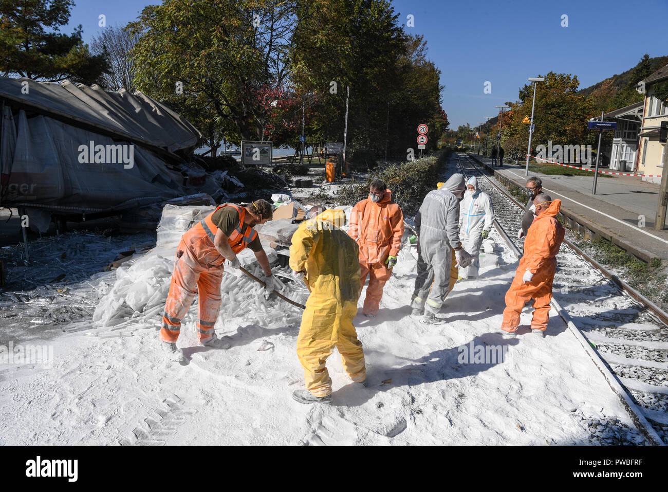 Baden-Wuerttemberg, Sipplingen Am Bodense, Germania. 15 ottobre, 2018. 15 ottobre 2018, Baden-Wuerttemberg, Sipplingen am Bodensee: Vigili del Fuoco rimuovere la farina di patate dai cingoli dopo un incidente tra un treno regionale e un carrello. In base alle attuali conoscenze, almeno 17 persone sono state leggermente ferite quando il treno entra in collisione con il carrello. Foto: Felix Kästle/dpa Credito: dpa picture alliance/Alamy Live News Foto Stock