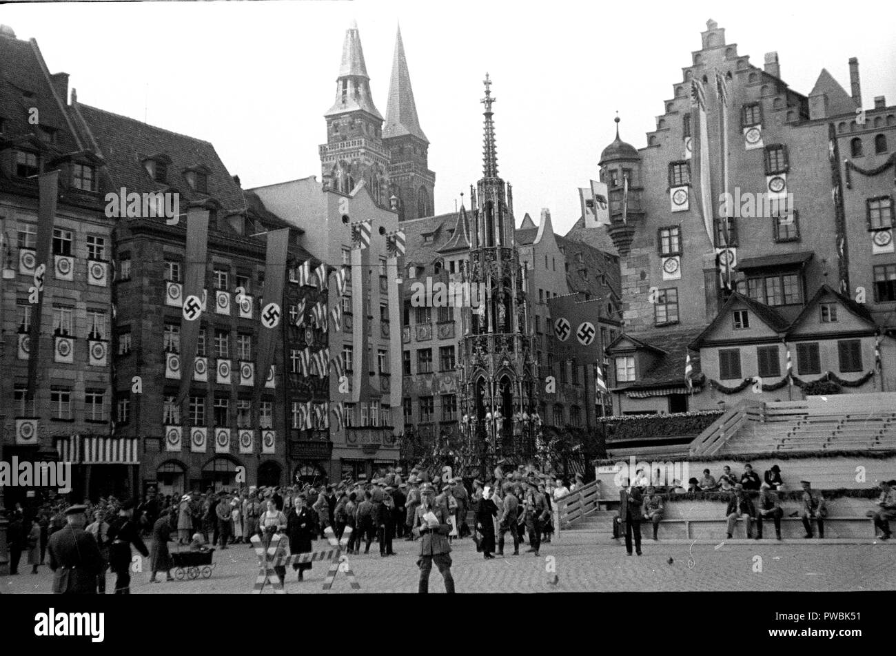 Tedeschi intorno al Schoene Brunnen o bella fontana nella piazza Hauptmarkt. Norimberga, Baviera, Germania per la Germania nazista NSDAP Nuremberg Rally 1936 Parade al rally terra 10 Settembre 1936 Foto Stock