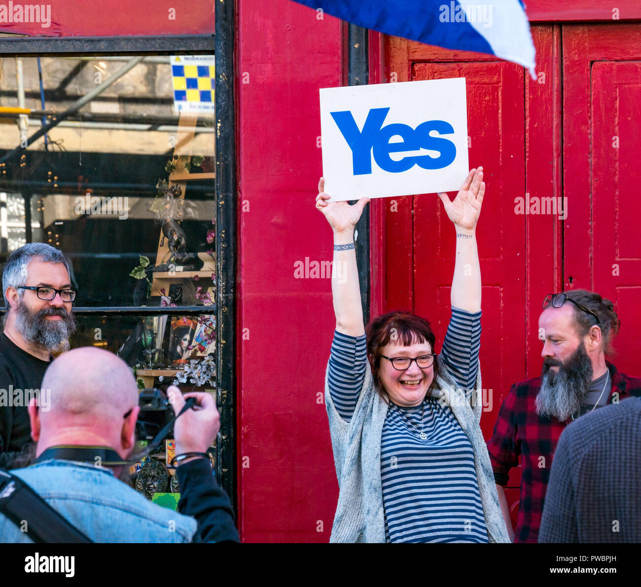 Donna orgogliosamente tenendo su Sì a tutti sotto uno striscione indipendenza scozzese marzo 2018, Royal Mile di Edimburgo, Scozia, Regno Unito Foto Stock
