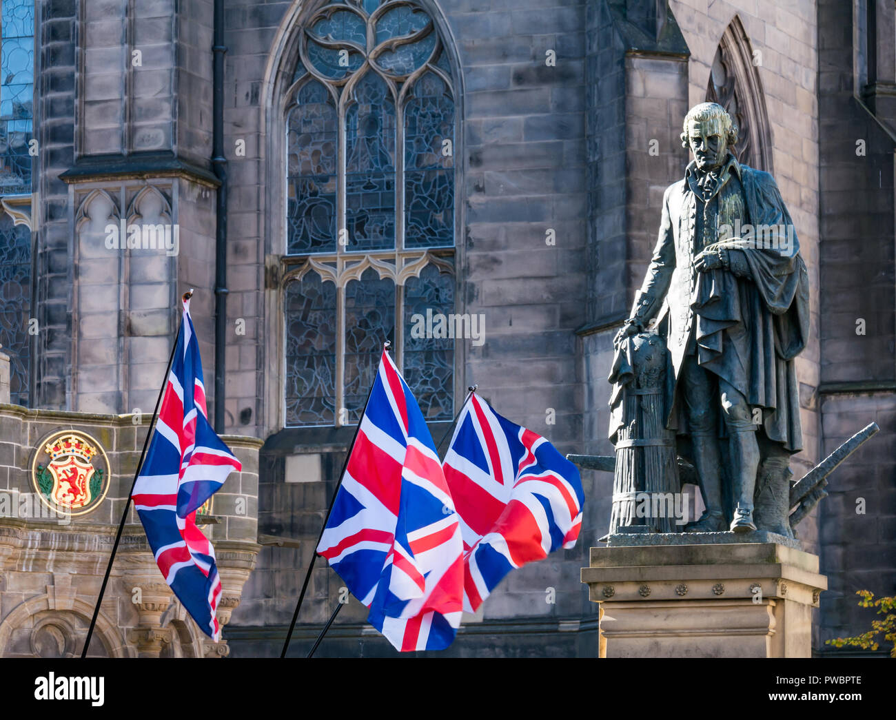 Union Jack sventolando bandiere a Adam Smith statua e la cattedrale di St Giles, tutti sotto uno striscione indipendenza marzo 2108, Royal Mile di Edimburgo, Scozia, Regno Unito Foto Stock