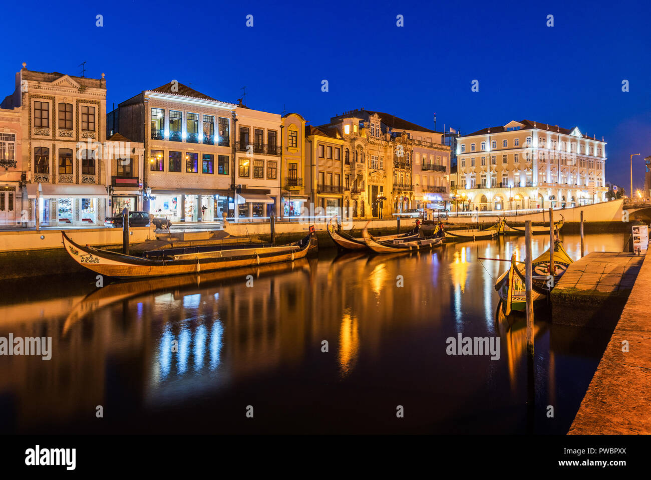 Canale centrale in Aveiro, con diversi moliceiros ancorato e case Art Nouveau in background al calar della sera. Centro della città di Aveiro, in Portu Foto Stock