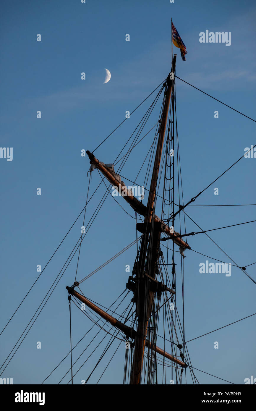 Il montante e armamento di una nave a vela con una falce di luna nel cielo in Victoria, British Columbia, Canada. Foto Stock