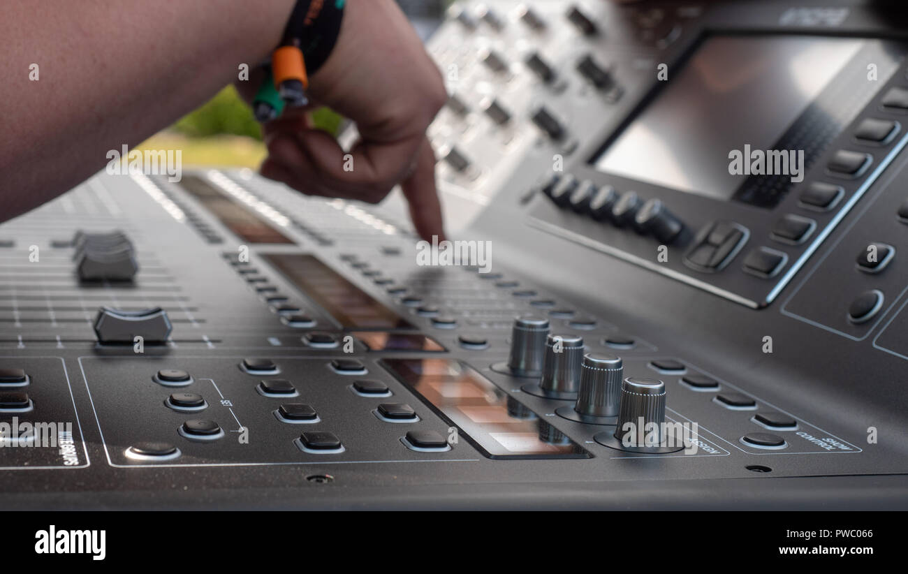 Ingegnere del suono nel controllo della sua digital mixing console prima di uno spettacolo Foto Stock