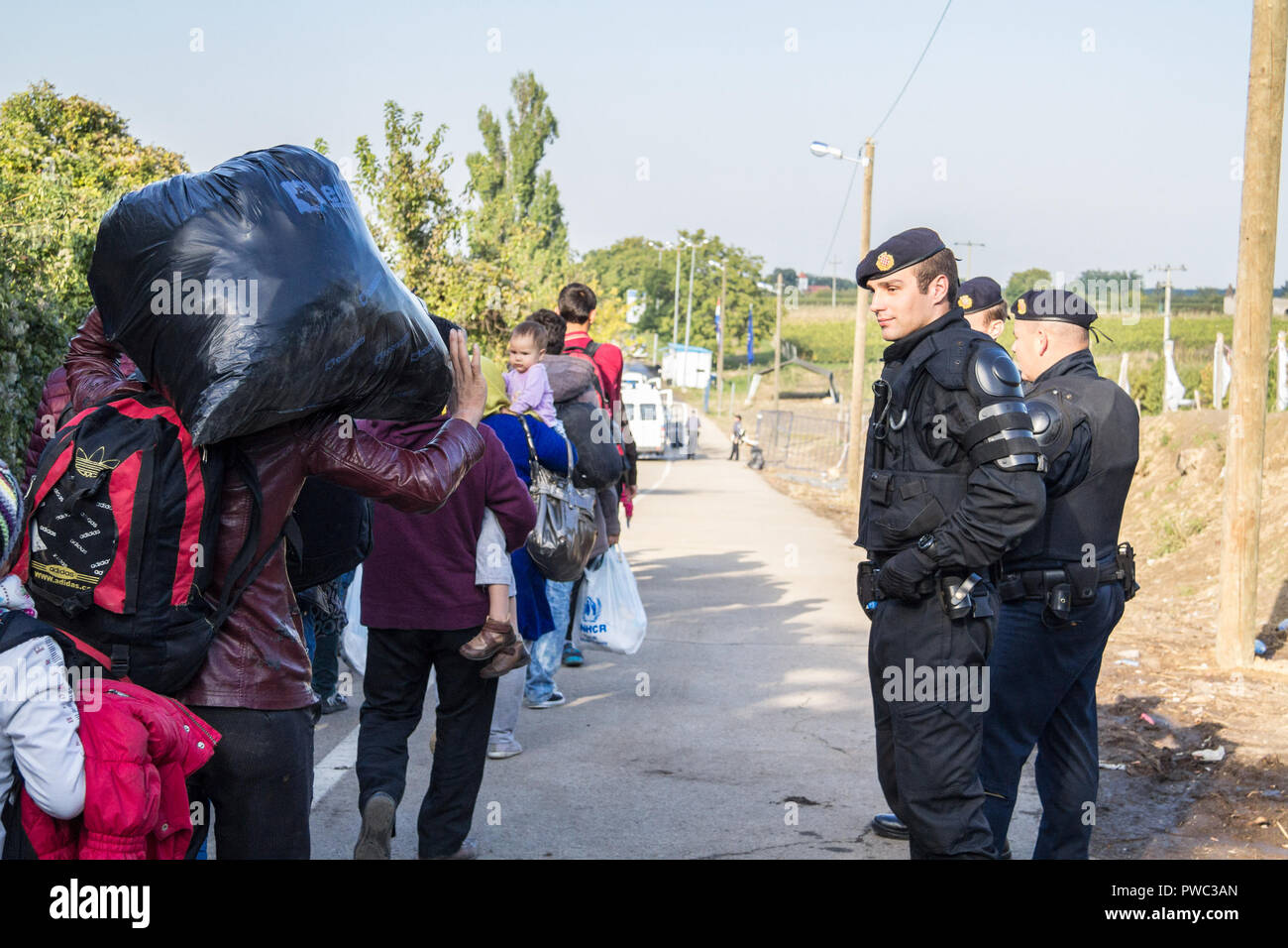 BERKASOVO, SERBIA - Ottobre 3, 2015: Croato poliziotto dalla polizia di frontiera guardando i migranti che attraversano la Serbia Croazia confine in Berkasovo Bapsk Foto Stock
