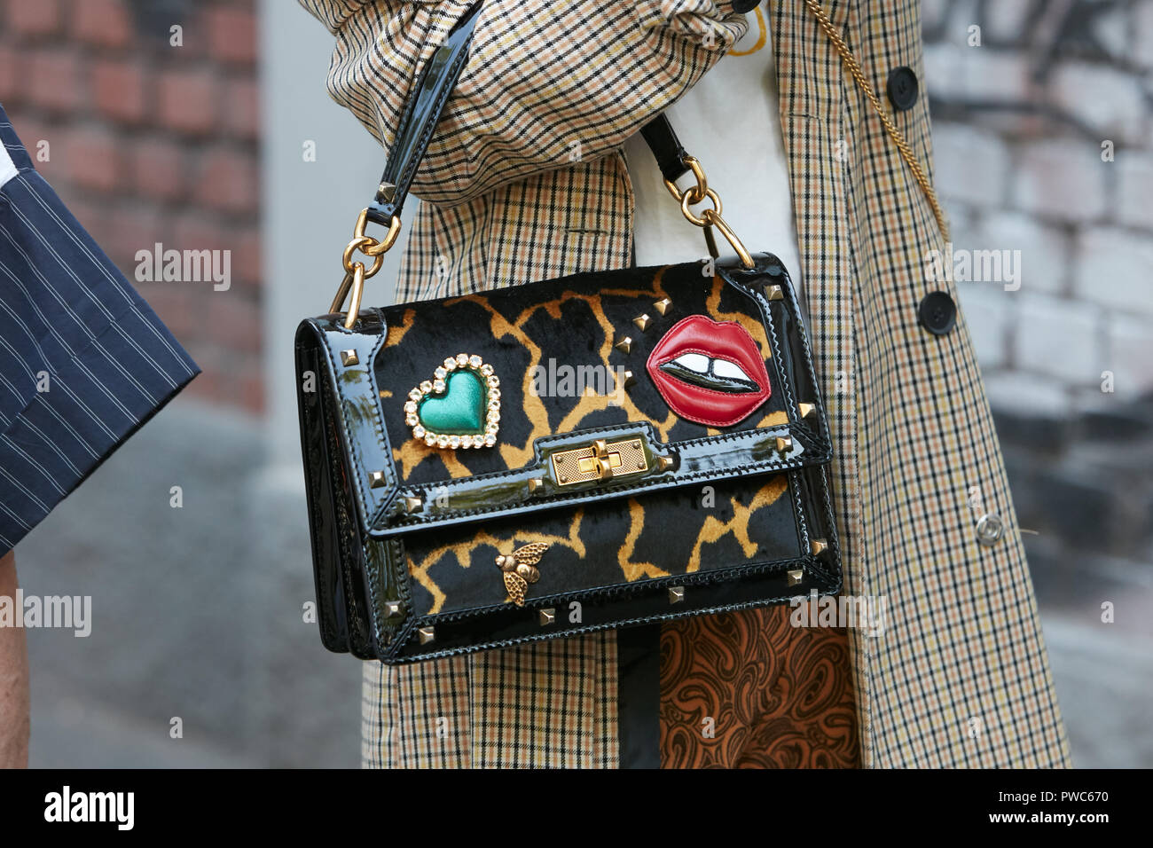 Milano, Italia - 20 settembre 2018: Donna con nero e borsa di pelliccia con bocca rossa e verde cuore prima di Fendi fashion show, la Settimana della Moda Milanese street st Foto Stock
