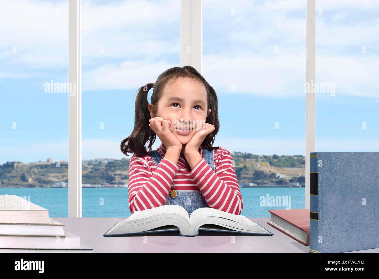 Carino ragazza asiatica di apprendimento con prenota at home Foto Stock