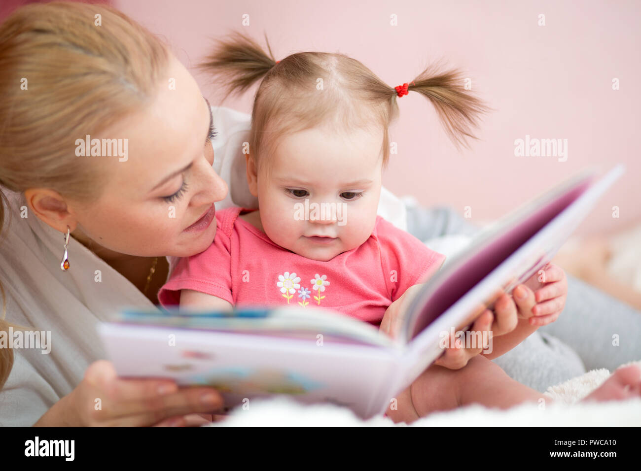 La mamma legge la sua bimba di un libro Foto Stock