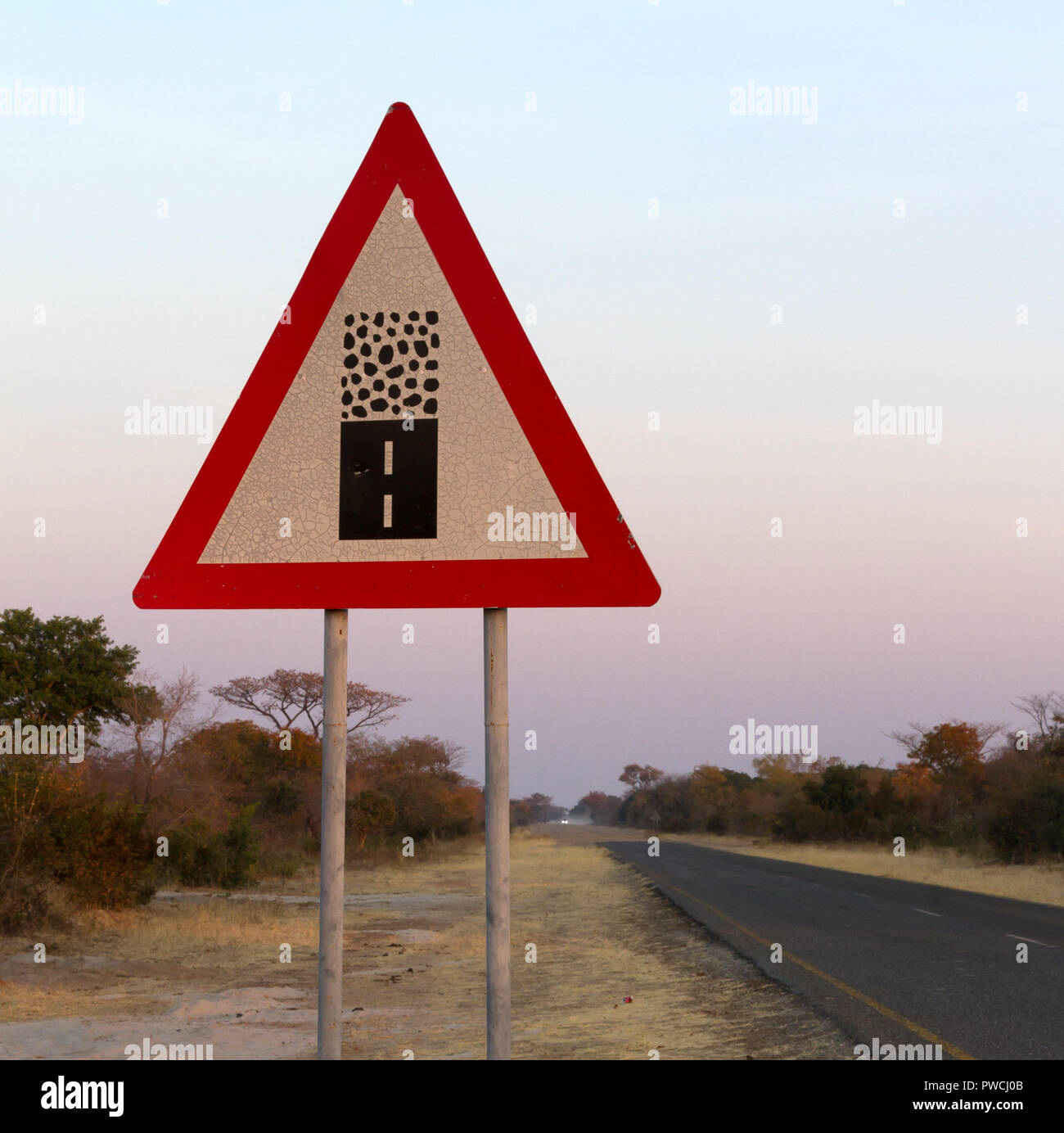 Segno strada di ghiaia - Attenzione alla fine di una buona strada, terminato l'asfalto, l'inizio di off road terreno Foto Stock