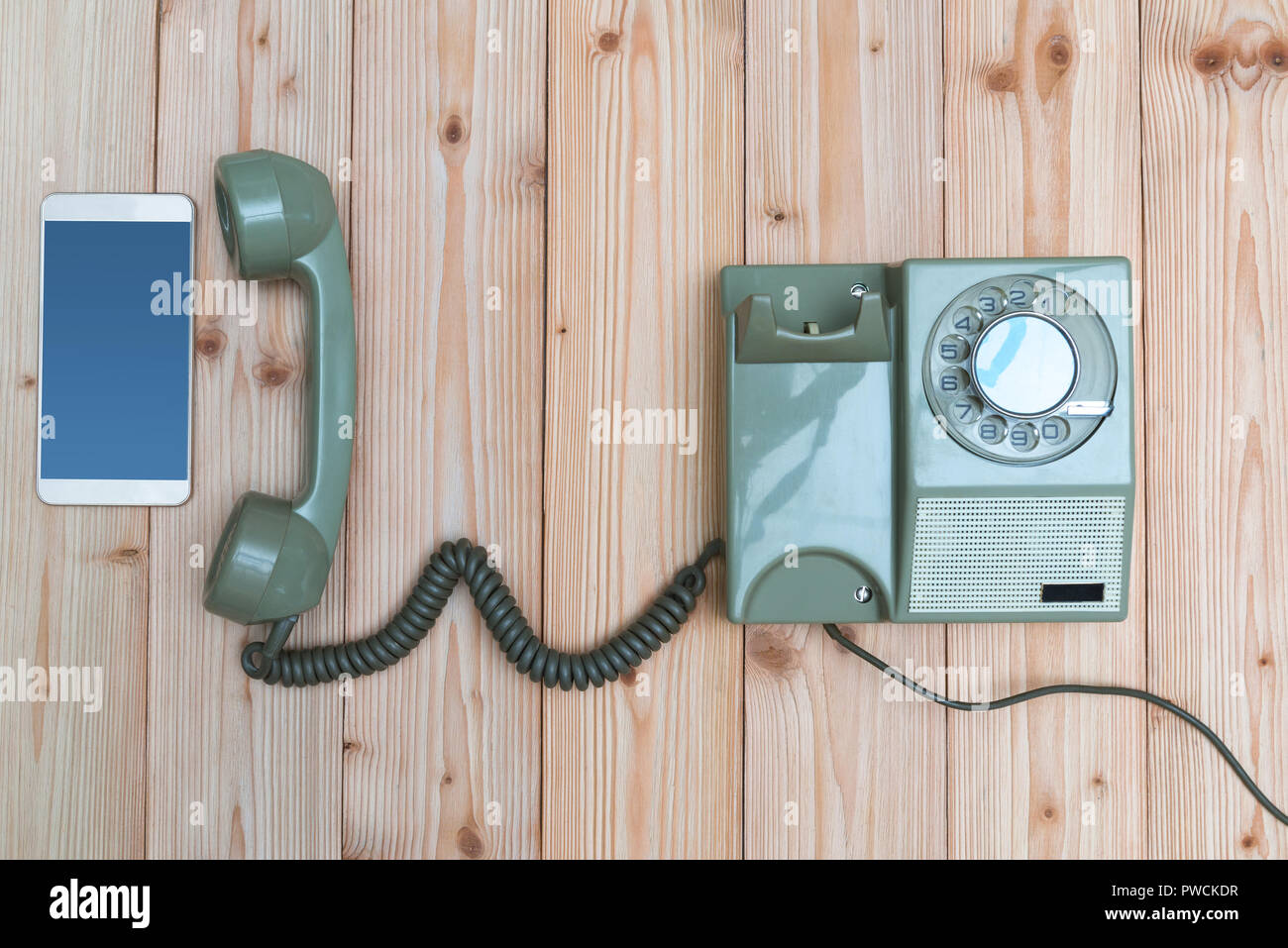 Retrò telefono rotante o vintage telefono con cavo e il nuovo telefono cellulare o smart phone su tavola di legno, vista dall'alto con copia spazio, concetto di tecnologia pr Foto Stock