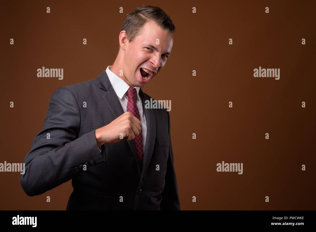 Studio shot di imprenditore contro sfondo marrone Foto Stock