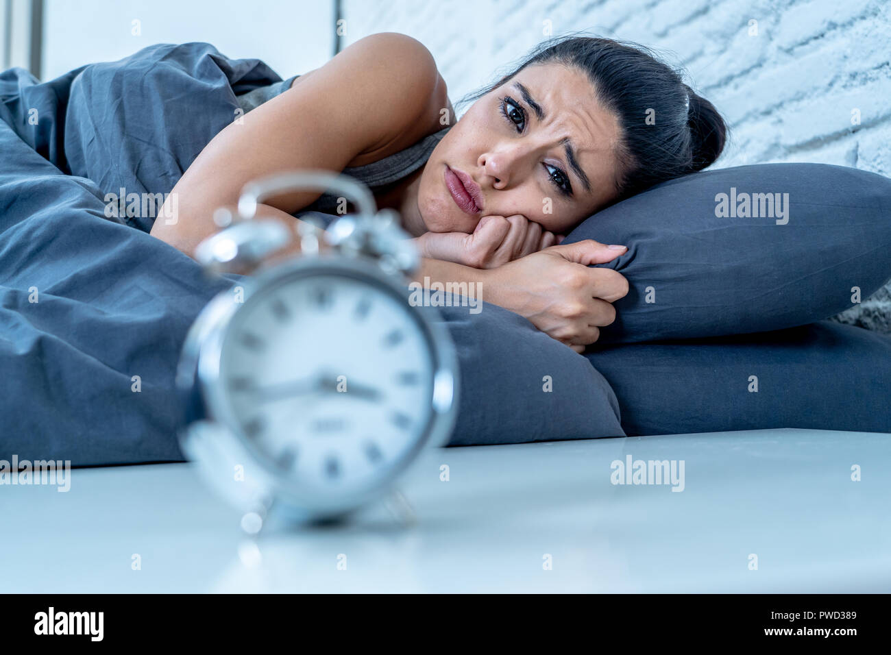 Insonne e disperato bella donna latina sveglio di notte non è in grado di  dormire guardando l'orologio che soffrono di insonnia in disturbo del sonno  concetto Foto stock - Alamy