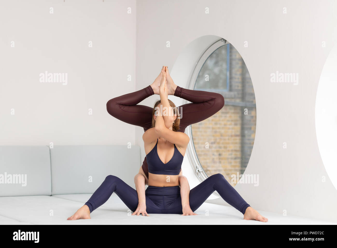 Due donne a praticare yoga insieme, acro yoga. Foto Stock