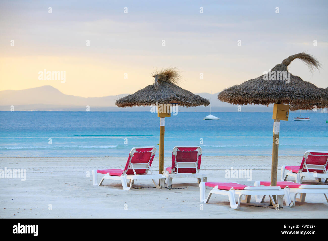 Vuoto di sedie a sdraio e ombrelloni sulla spiaggia di Port de Alcudia Foto Stock