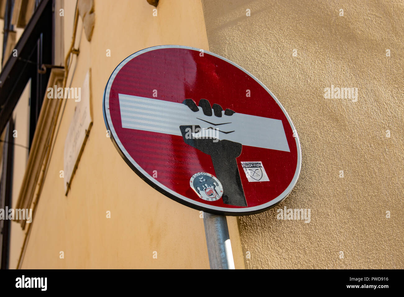 Una mano afferra e spreme la barra bianca in una non inserire segno sulle strade di Firenze, Italia. Foto Stock