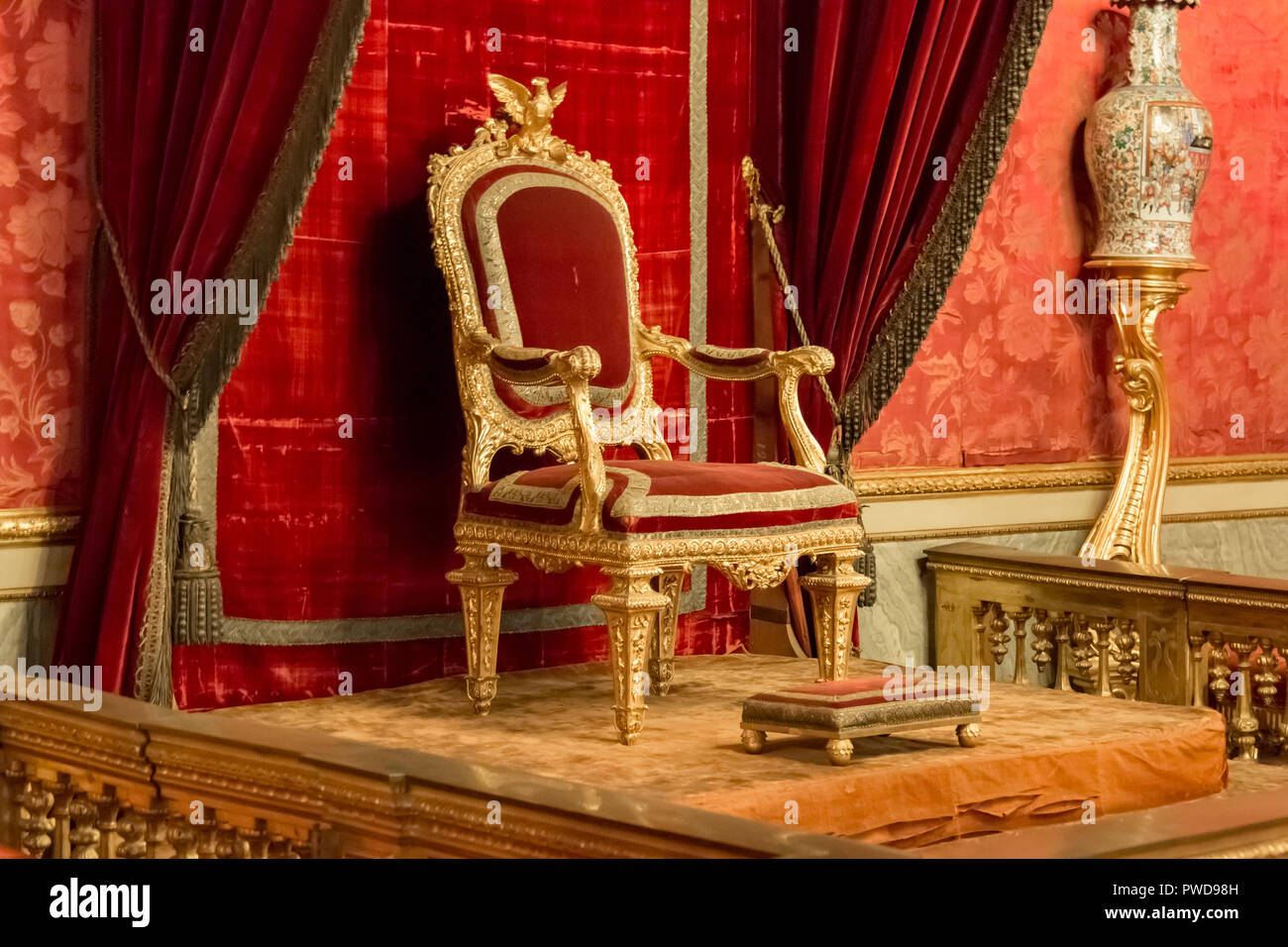 Il trono nella Sala del Trono di Palazzo Pitti è fatto in ricchi colori rosso e oro e con damasco tutto intorno. Foto Stock