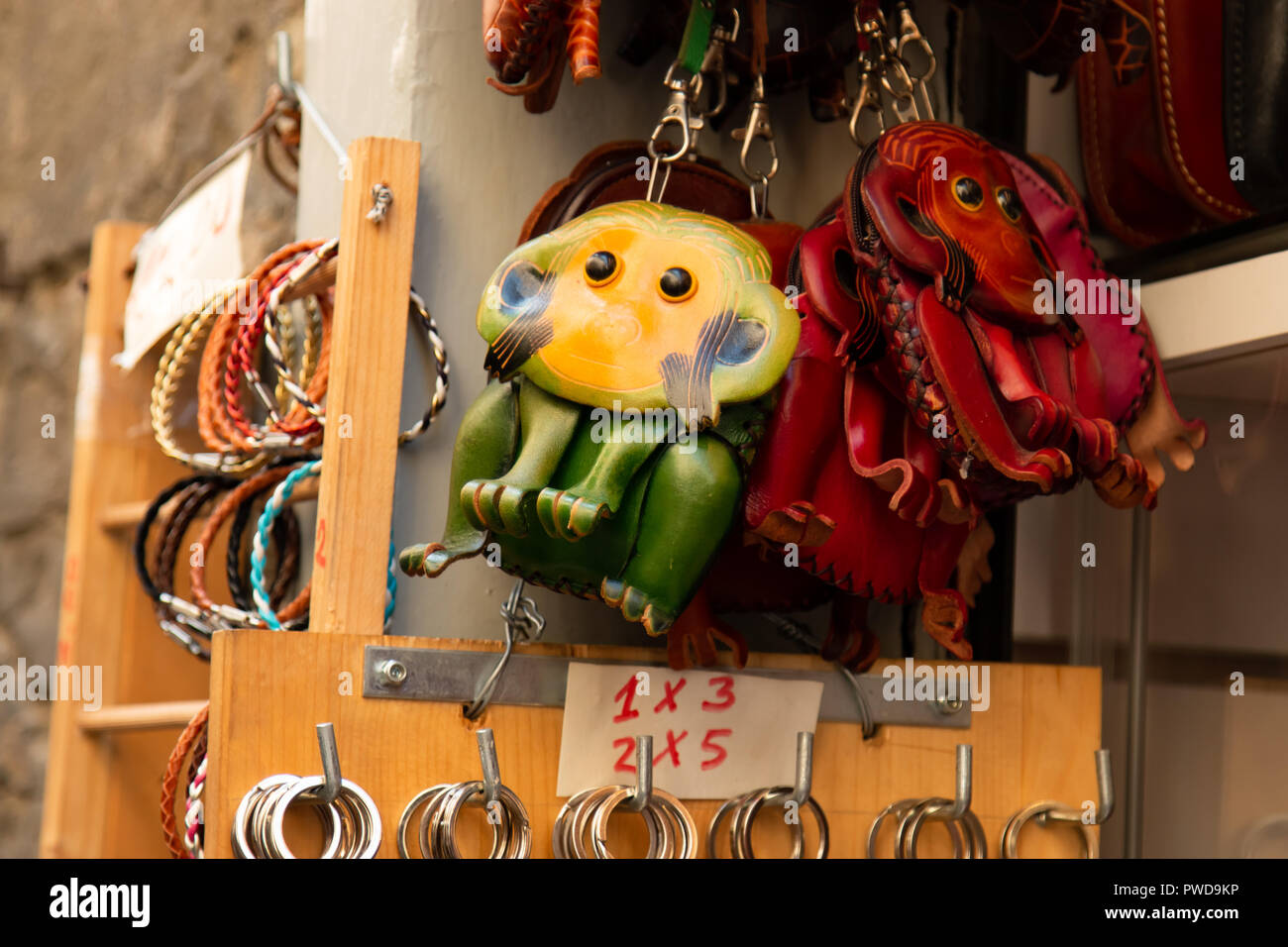 Piccole monete in pelle portamonete in colori luminosi e forme animali sono in vendita presso un negozio di Firenze, Italia. Foto Stock