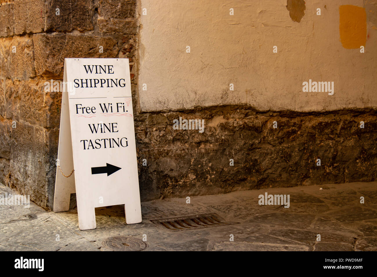 Un sandwich board pubblicità una degustazione di vino shop con wifi gratuito in un vicolo a Firenze, Italia. Foto Stock Un sandwich board pubblicità una degustazione di vino shop con wifi gratuito in un vicolo a Firenze, Italia. Foto Stock