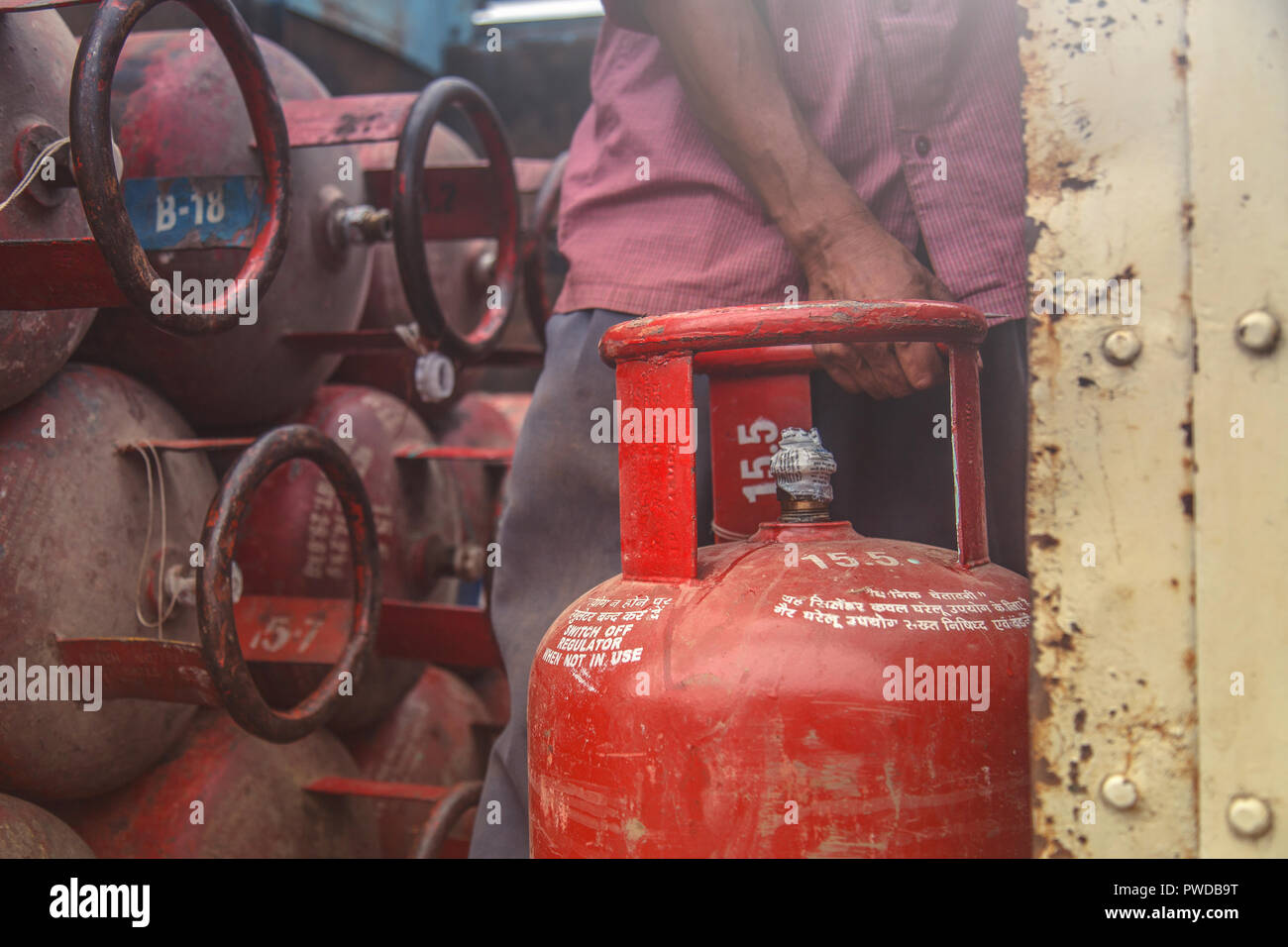 Lavoratore erogazione di gas GPL in bombole il carrello per i clienti Foto Stock