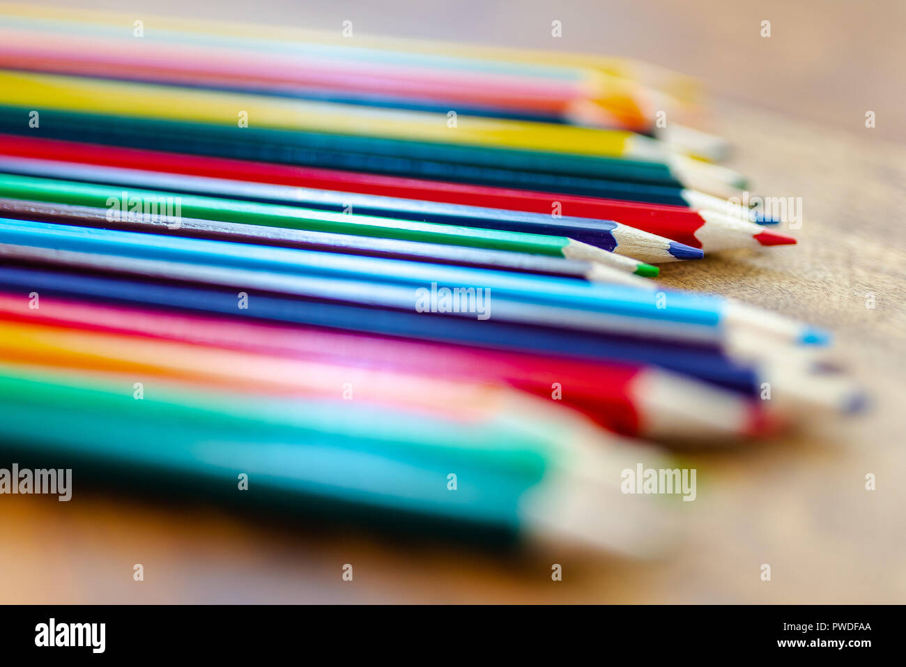 Matite colorate su scrivania in legno Foto Stock