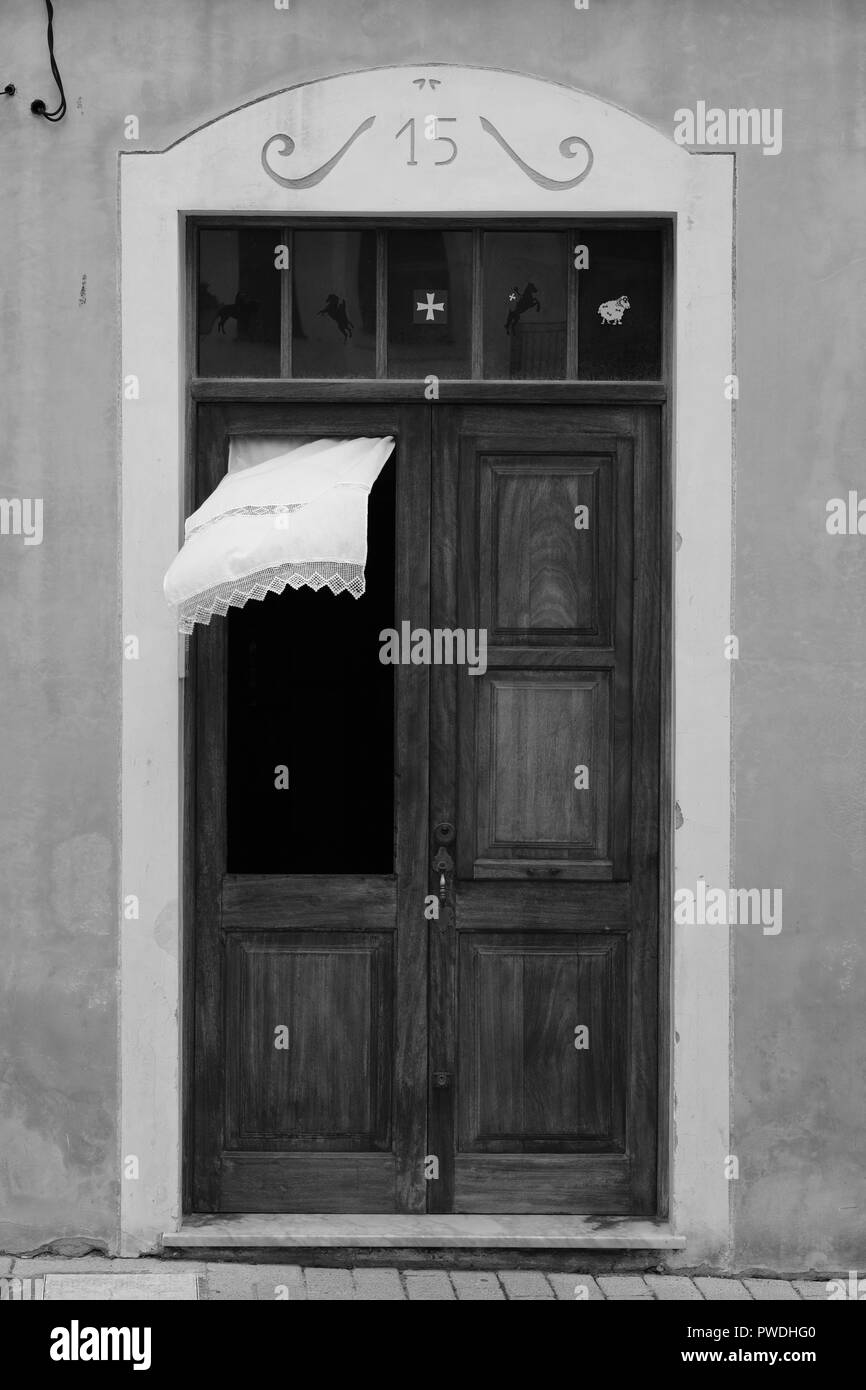 La tendina di pizzo che fluttua nel vento attraverso la finestra di una porta di legno in Ciutadella menorca Spagna Foto Stock