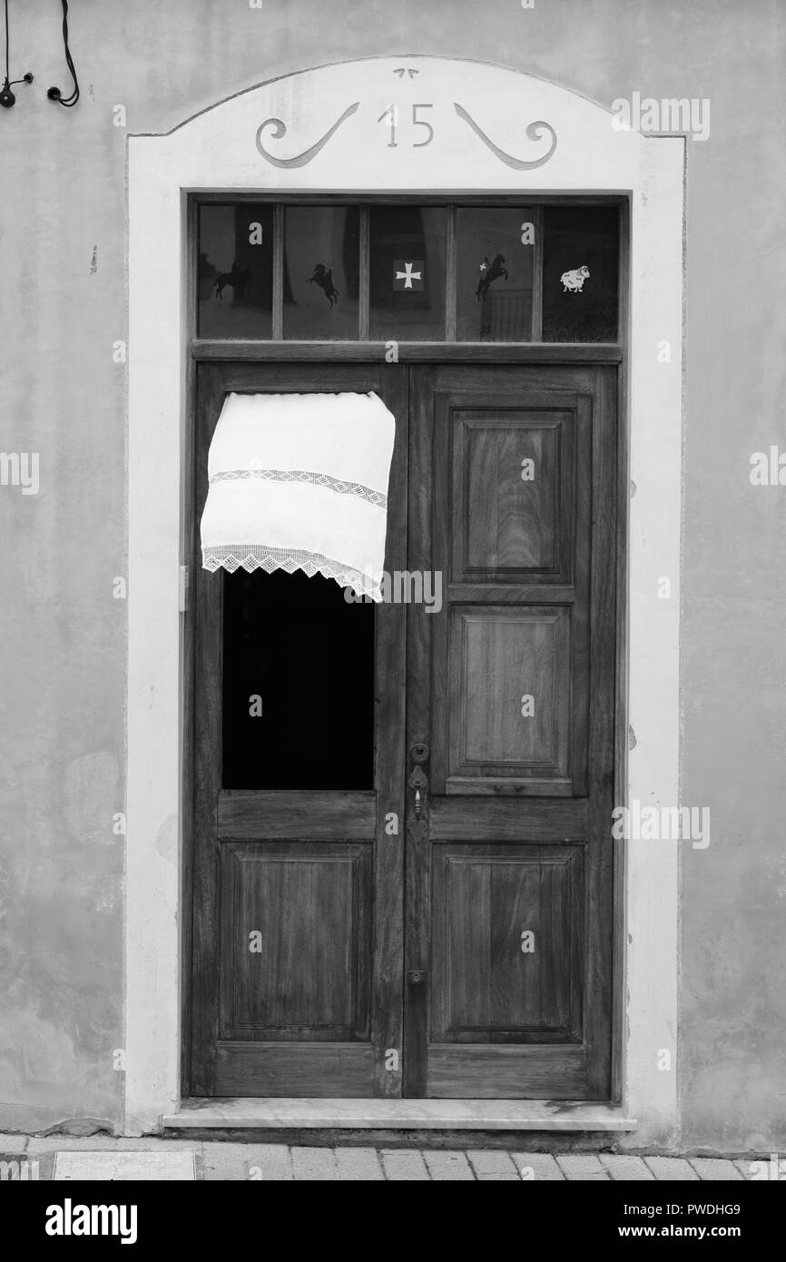 La tendina di pizzo che fluttua nel vento attraverso la finestra di una porta di legno in Ciutadella menorca Spagna Foto Stock