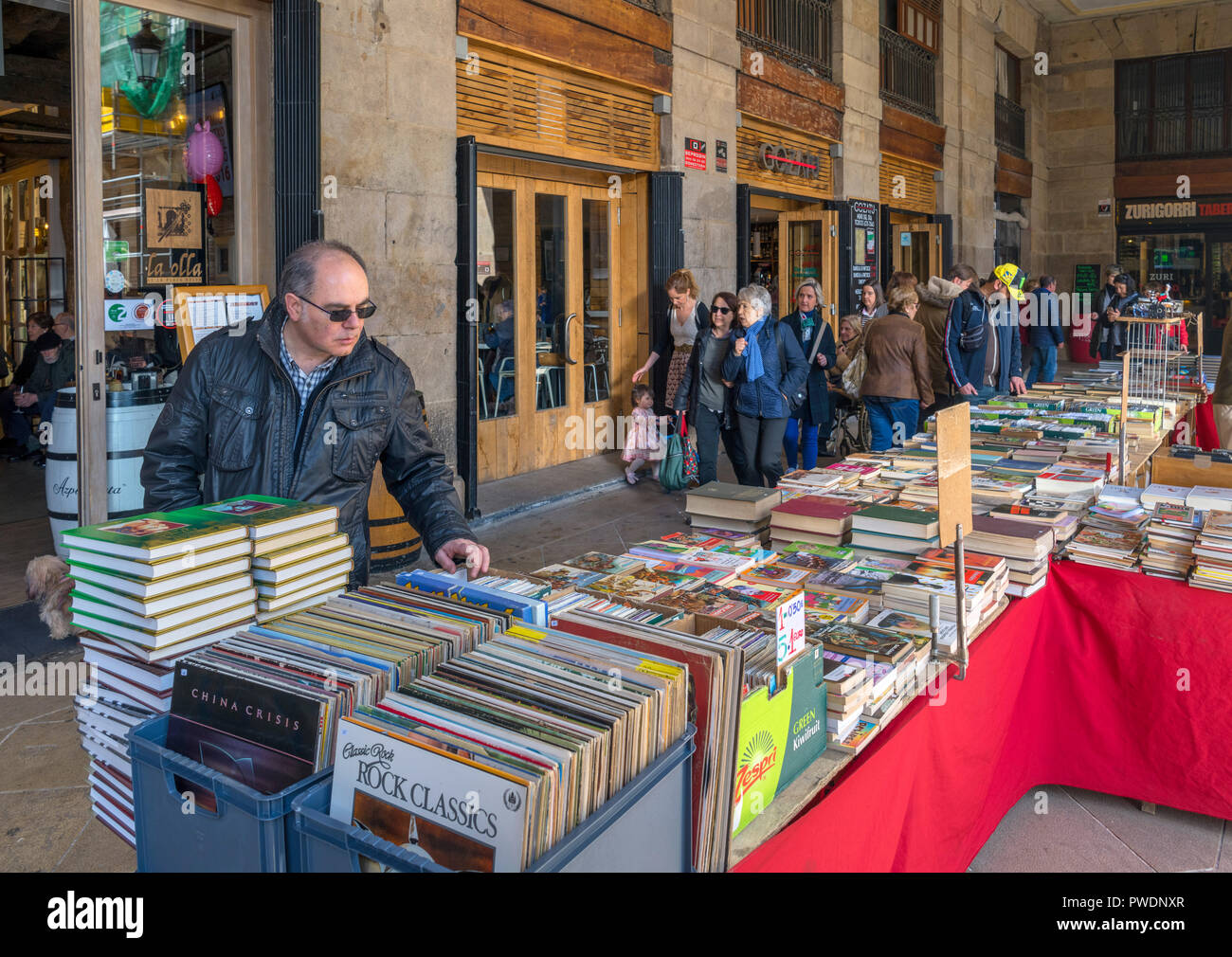 Uomo che guarda la seconda mano libri e LP in vinile registra su un mercato in stallo in Plaza Nueva, Casco Viejo, Bilbao, Paesi Baschi Foto Stock