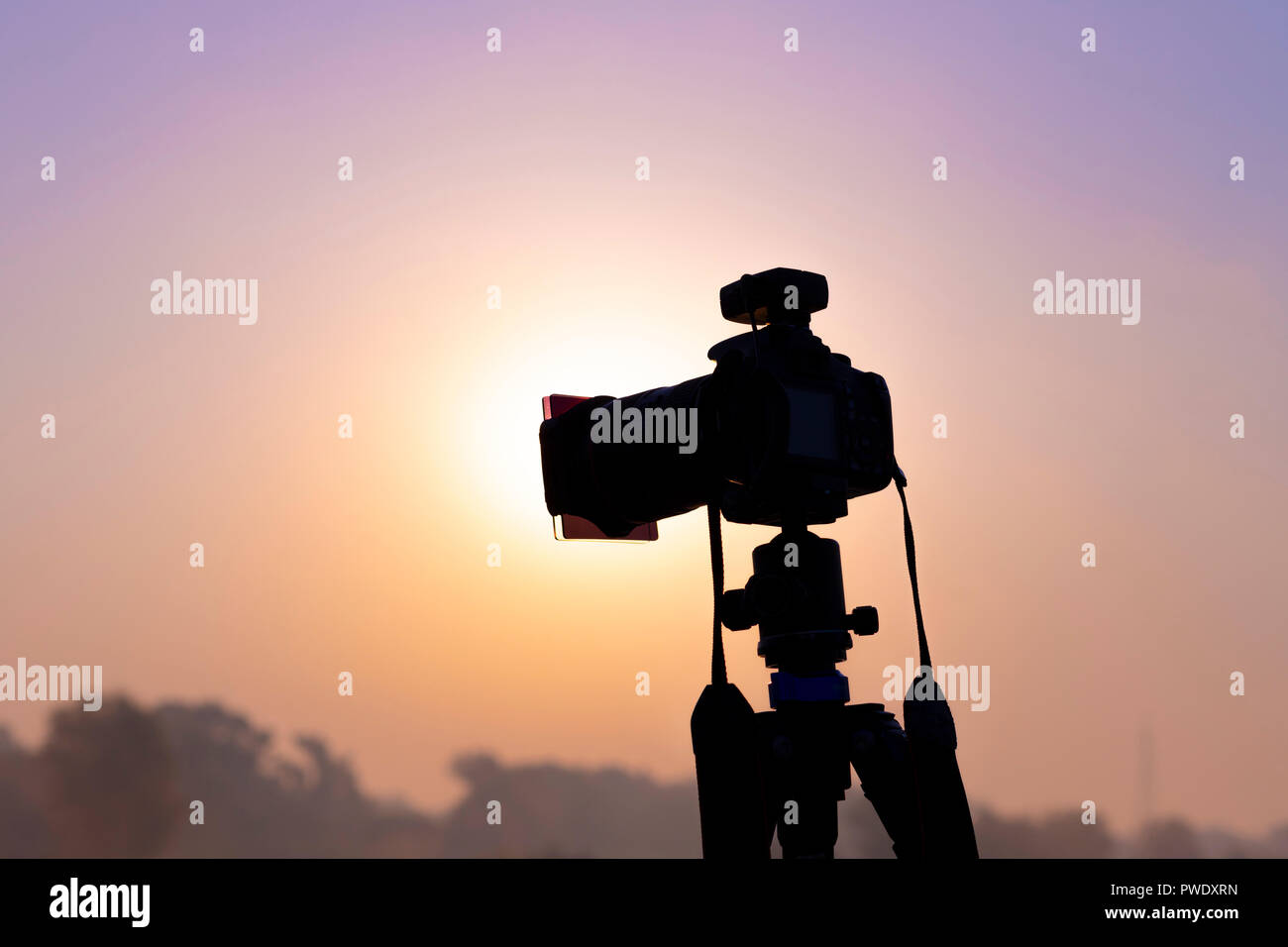 La fotocamera su un treppiede di scatto a sunrise Foto Stock
