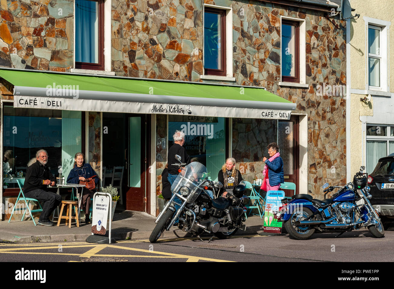 Schull, West Cork, Irlanda. 15 ottobre, 2018. I turisti e i locali fanno la maggior parte del tempo soleggiato e sedersi al di fuori di una caffetteria locale per consumare il loro tè e caffè. Il giorno rimarrà soleggiato con indeciso previsioni meteo per il resto della settimana. Credito: Andy Gibson/Alamy Live News. Foto Stock