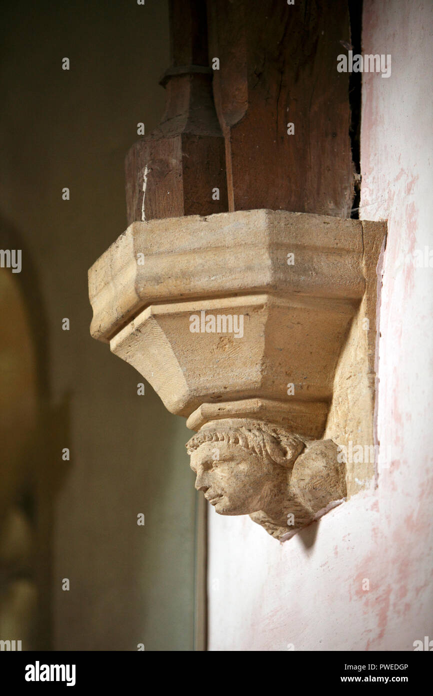 Testa scolpita in pietra alla base di un arco. Plantare. St James il Grande, Fulbrook chiesa. Oxfordshire. Muratori art. Foto Stock