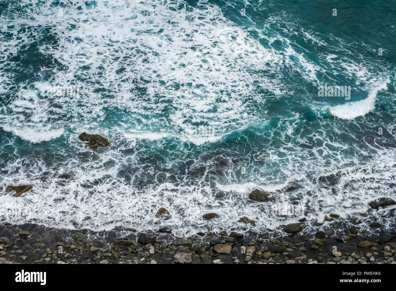 Costa dell'oceano, antenna ghiaiosa spiaggia di pietra e le onde - Foto Stock