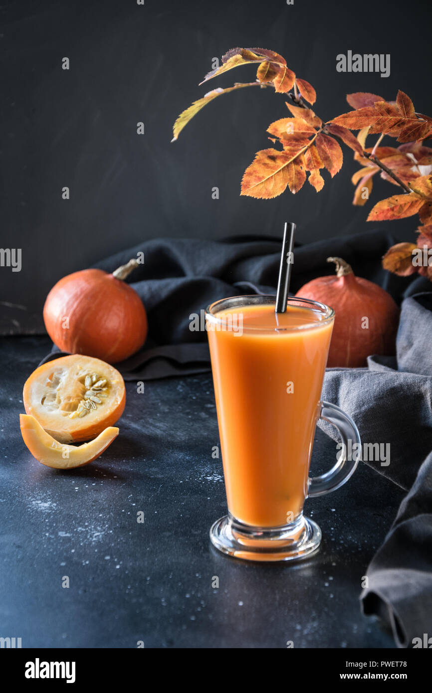 Fresco frullato di zucca o succo di frutta sulla scura. Autunno autunno o inverno bevanda calda. Accogliente bevanda salutare. Foto Stock