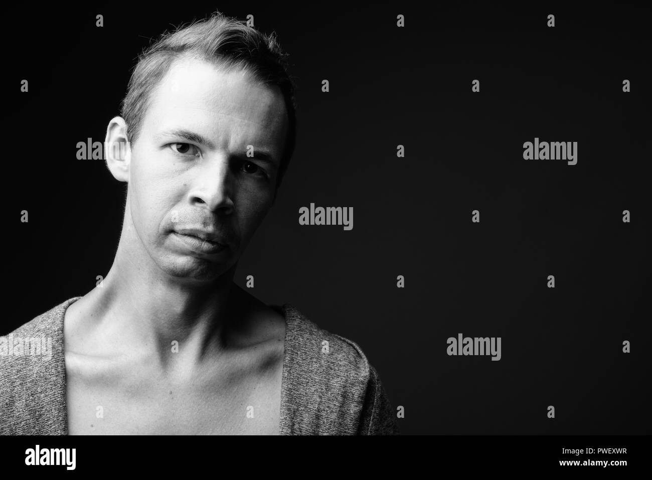 Uomo ribelle contro lo sfondo nero in bianco e nero Foto Stock